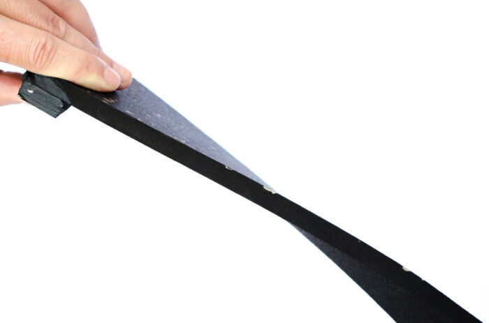 A person holding onto the end of a black ribbon